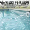 Primer plano a nivel del agua de una piscina de azulejos azules con una boquilla de retorno blanca expulsando un chorro de agua limpia.