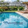 Una mujer sonriente en traje de baño y sombrero de paja limpia una piscina residencial de lujo con un saca hojas de alberca en Querétaro. La piscina de azulejos azules está rodeada de palmeras y una terraza de madera. En primer plano, productos de limpieza. Texto superpuesto: 'CÓMO TENER UNA ALBERCA IMPECABLE CON UNA RUTINA DE LIMPIEZA DE 15 MINUTOS'. Logotipo visible: 'Aquasistemas de Querétaro'.